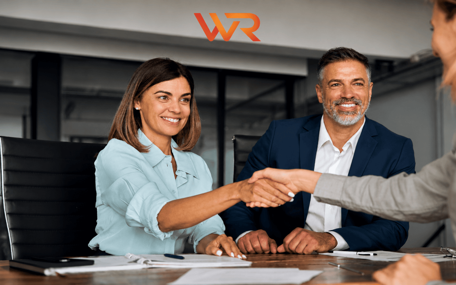 Business people shaking hands in a meeting.