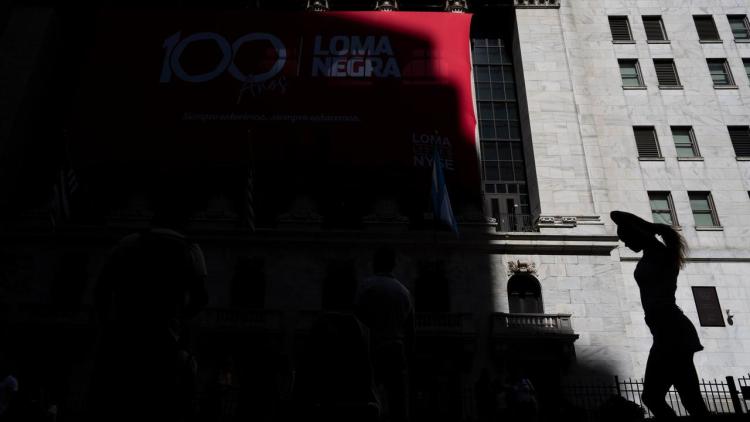A woman walks by the New York Stock Exchange