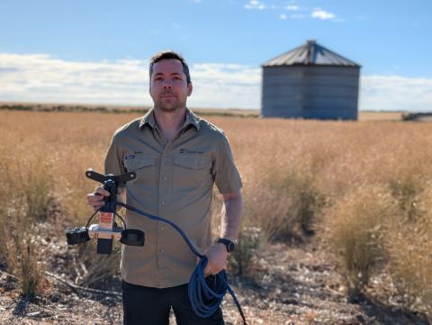 Rain Plaado, founder of SnailCam holding the device that goes onto farm machinery to track pest movements. Photo: Supplied.